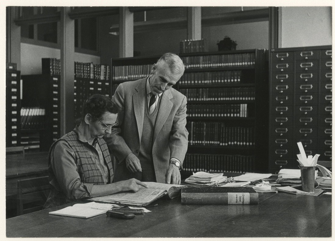 Rijswijkseplein-Gemeentearchief, de heer F.C.L. Raadsveld helpt een bezoeker van de studiezaal, 1966 HGA